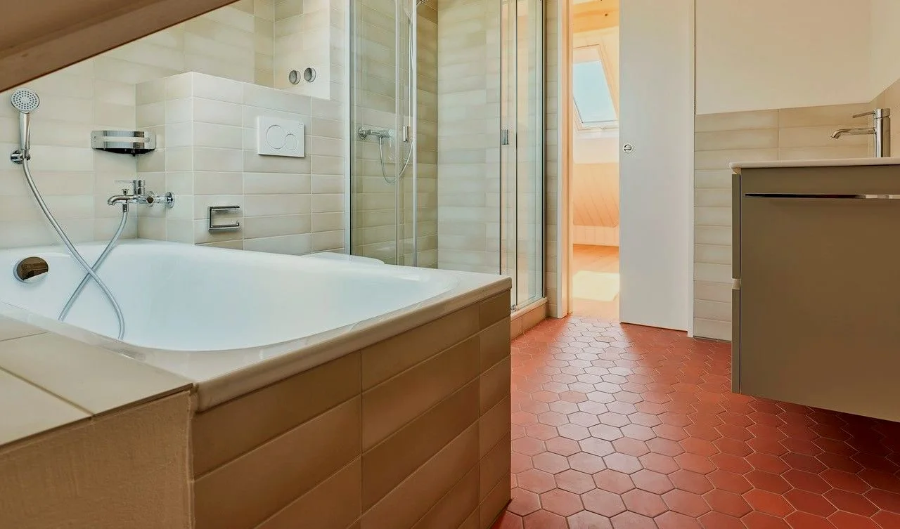 Modern renoviertes Badezimmer mit Glasdusche und Badewanne.
