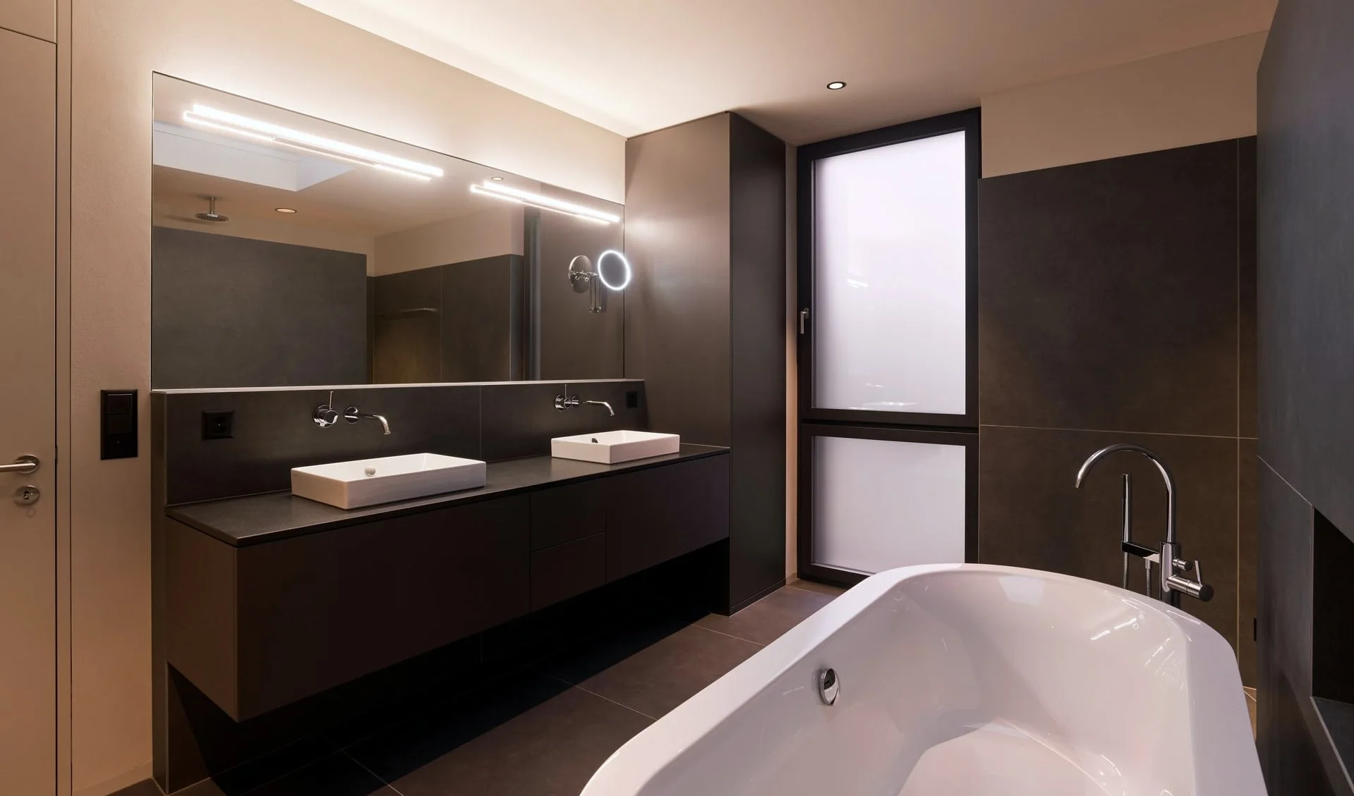 Modernes Badezimmer mit freistehender Badewanne und Doppelwaschtisch.