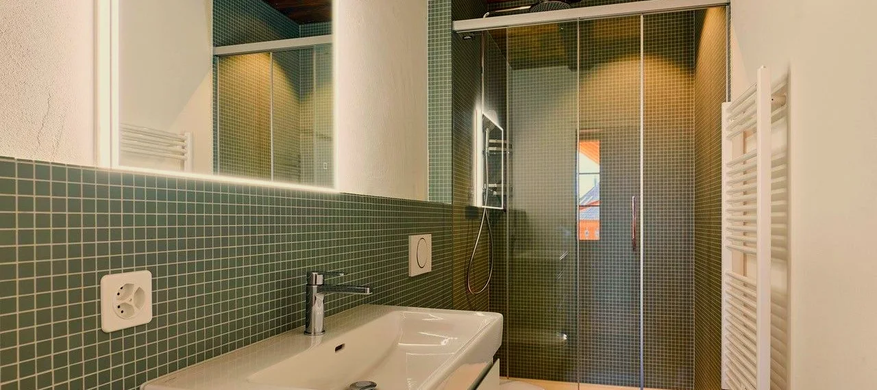 Sanitärinstallation mit Waschtisch und Mosaikfliesen.